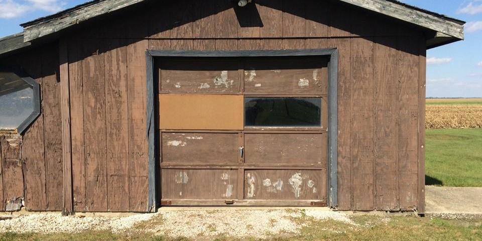 Badly damaged commercial garage door before repair- Glenn Brothers - Springfield, IL