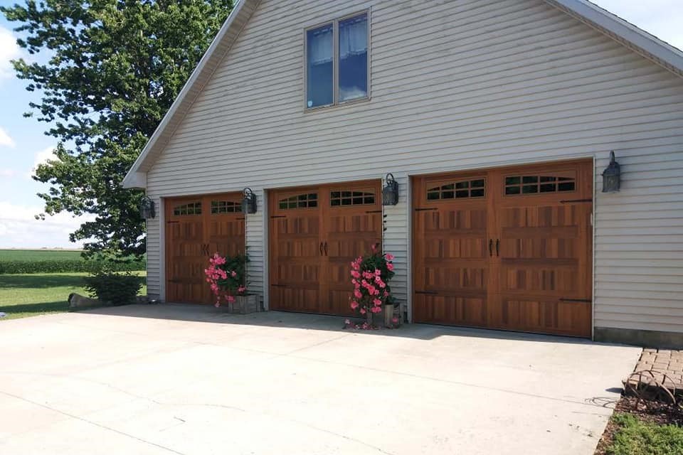 3 Beautiful wooden barndoor style single garage doors on Residential home - Glenn Brothers - Springfield, IL