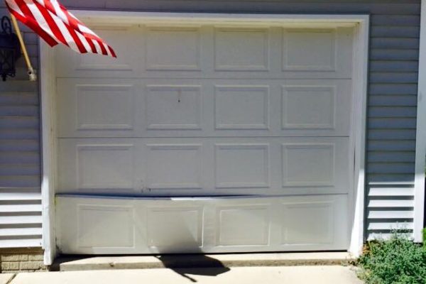 Badly damaged residential garage door before repair- Glenn Brothers - Springfield, IL