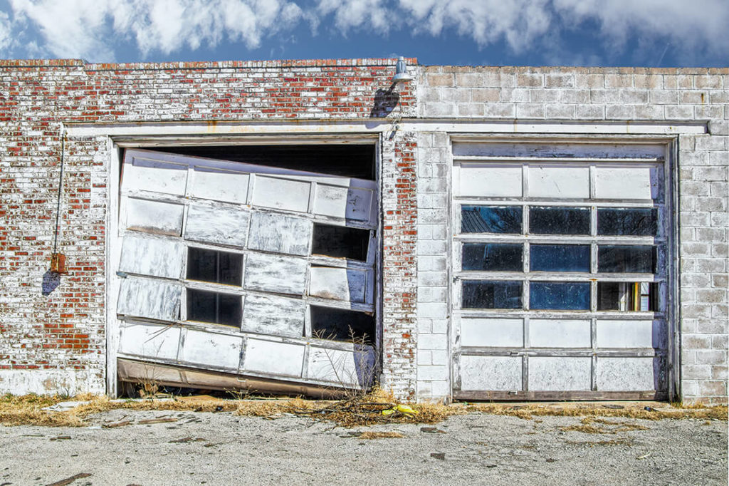 badly damaged commercial garage doors after a storm - Taylorville, IL